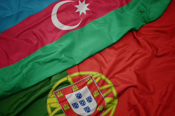 waving colorful flag of portugal and national flag of azerbaijan.