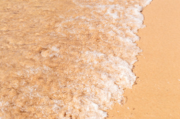 Wave of the sea on the sandy beach.