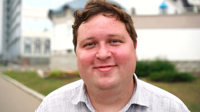 Funny man making shy or confused face close-up outdoor