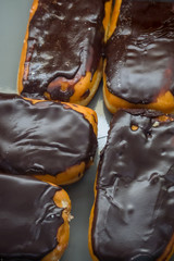 Fresh delicious eclairs on store shelves in supermarket table, close-up