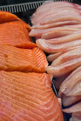 Fresh atlantic salmon and white fish on store shelves in supermarket table, close-up