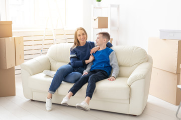 Young cute single mother and son are happy about the move to new house. Concept of housewarming and family space extensions.