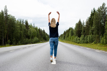 Girl walking on an empty road. New way. Forward movement to the future. Casual look. Enjoy the moment, relaxation. Lonely beautiful women. Wanderlust. Travel, adventure, lifestyle. Explore Finland 