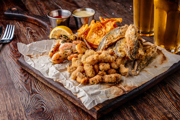 Set seafood: mussels, shrimps, small fried sea fish, crackers and sauces, food that is usually served with beer, horizontal orientation