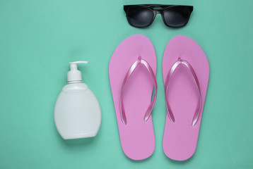 Summer still life. Beach accessories. Fashionable beach pink flip flops, sunblock bottle,...