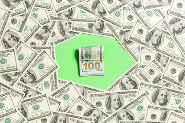 Fototapeta premium Frame of one hundred dollar bills with stack of money in the middle. Top view of business concept on green background with copy space