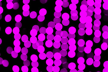 Unfocused abstract pink bokeh on black background. defocused and blurred many round light