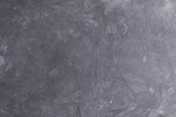 Abstract handmade gray grunge background imitating a concrete or cement surface painted with tinted acrylic paint. Empty space for text and design elements.