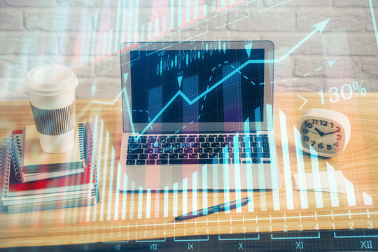 Double exposure of graph and financial info and work space with computer background. Concept of international online trading.
