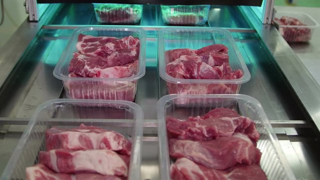 Packing of meat slices in boxes on a conveyor belt