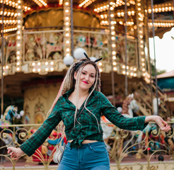 Cheerful emotional woman with dreadlocks hairstyle in an amusement park. Lifestyle Concept