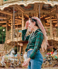 Cheerful emotional woman with dreadlocks hairstyle in an amusement park. Lifestyle Concept