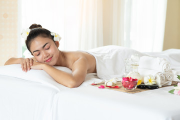 Obraz na płótnie Canvas Beautiful Asian woman lying down on massage bed relaxing in spa salon