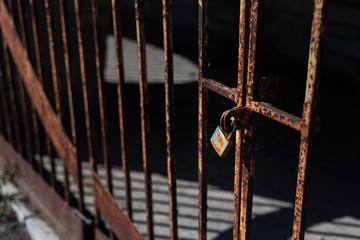 rusty lock on barred gate