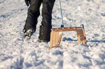 Schlitten wird auf einer Schneepiste durch eine Person nach oben gezogen, Niemand