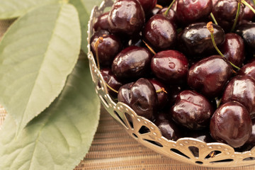 Sweet cherries in a round wooden bowl, close-up