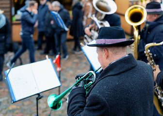 Man playing trumpets at Christmas market in Charlottenburg Berlin - obrazy, fototapety, plakaty