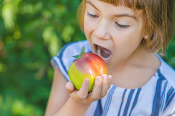 child with an apple in the garden. Selective focus.