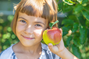 child with an apple in the garden. Selective focus.