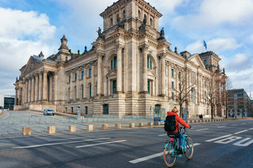 Fototapeta premium Lady on bicycle Reichstag building with German Flags Berlin