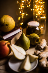 The photo shows fresh pears, a jar of jam and ginger root on the background of the tablecloth.