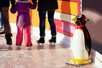 Penguin skate aids and assistant and family doing skating Berlin