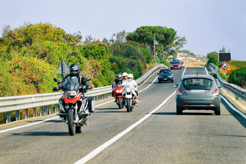 Motorcycles and cars in road in