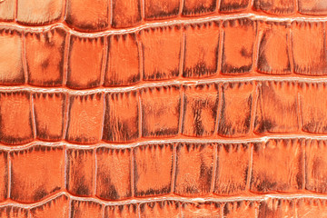 Texture of brown genuine leather close-up, with embossed scales reptiles, fashion trend pattern