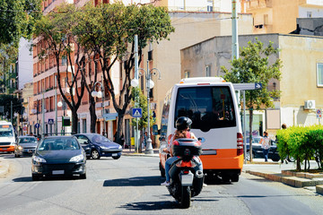 Fototapeta na wymiar Street view on Road with cars scooter shuttle bus Cagliari