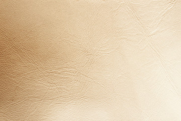 Texture of genuine leather close-up, surface close-up with wrinkles and cracks, beige brown color print, trendy background