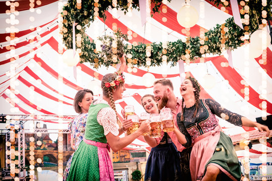 Gruppe von Freunden tanzt auf Bierbank im Festzelt Dult, Regensburg, Oktoberfest