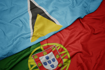 waving colorful flag of portugal and national flag of saint lucia.