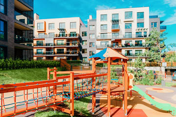 Fototapeta na wymiar Children playground and European modern residential buildings quarter