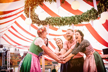 Gruppe von Freunden mit Bier auf der Bierbank tanzt auf der Dult Oktoberfest Regensburg München 