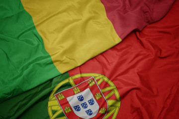waving colorful flag of portugal and national flag of mali.