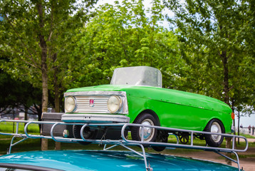 A small Soviet children's car on the trunk of a large car