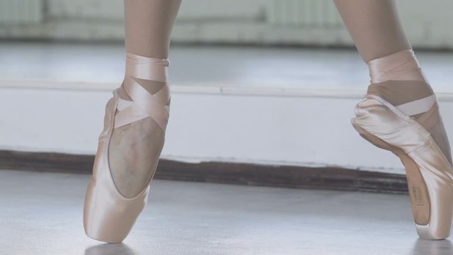graceful ballerina legs in pointe shoes. girl dancing in the old dance hall slow motion