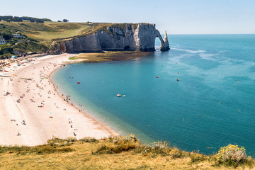 Aerial panoramic view of Etretat coastline with white chalk cliffs, Aiguille d'Etretat, natural stone arch and the beach. Etretat, Normandy, France. 