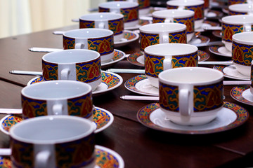 rows of pure colorful cup and saucer with teaspoon