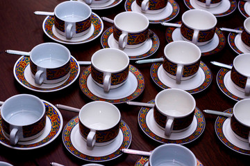 rows of pure colorful cup and saucer with teaspoon