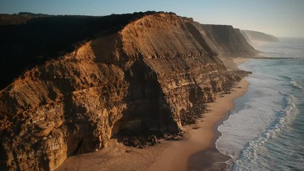 Aerial view of the Sao Juliao beach in Sintra, Portugal. Beach of Atlantic ocean with high cliffs of coastline. Drone view