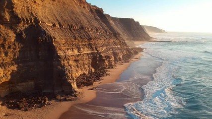 Aerial view of the Sao Juliao beach in Sintra, Portugal. Beach of Atlantic ocean with high cliffs of coastline. Drone view