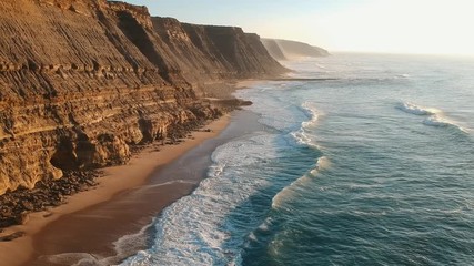 Aerial view of the Sao Juliao beach in Sintra, Portugal. Beach of Atlantic ocean with high cliffs of coastline. Drone view