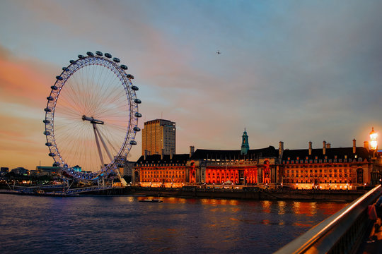 London Eye Ferris Wheel and County Hall in London dusk