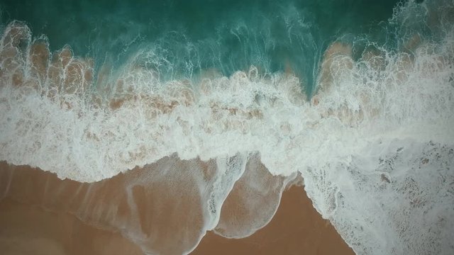Aerial view waves break on white sand beach. Sea waves on the beautiful beach aerial view drone