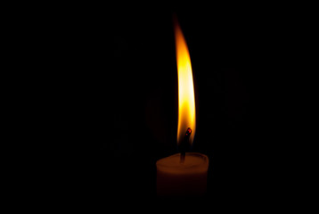 A burning candle with black background