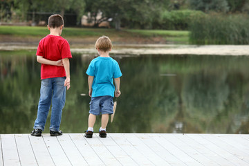 two boys looking standing on a dock