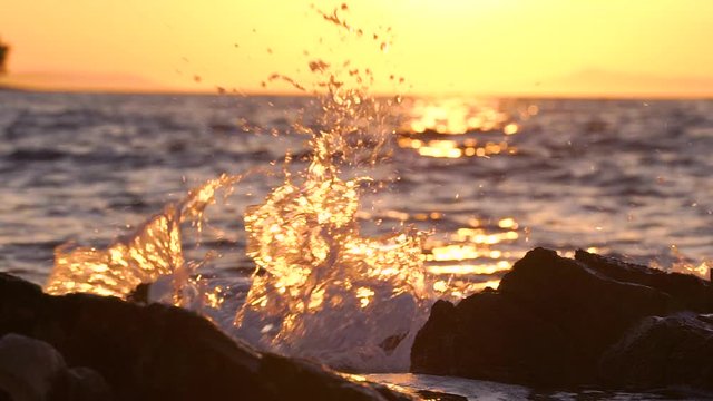 Slow motion image of seawater breaking at shore during a scenic sunset, Croatia.