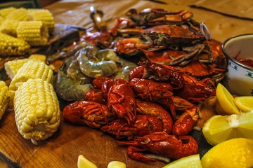 Ingredients for a traditional Cajun seafood boil with crab shrimp crawfish corn andouille sausage onions and red potatoes lemon onions selective focus 