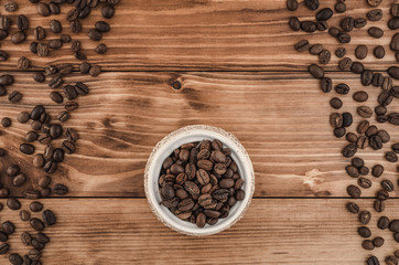Coffee lines and beens in white pot on brown wooden background. Top view